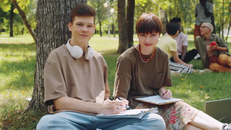 Portrait-of-College-Girl-and-Boy-Studying-in-Park